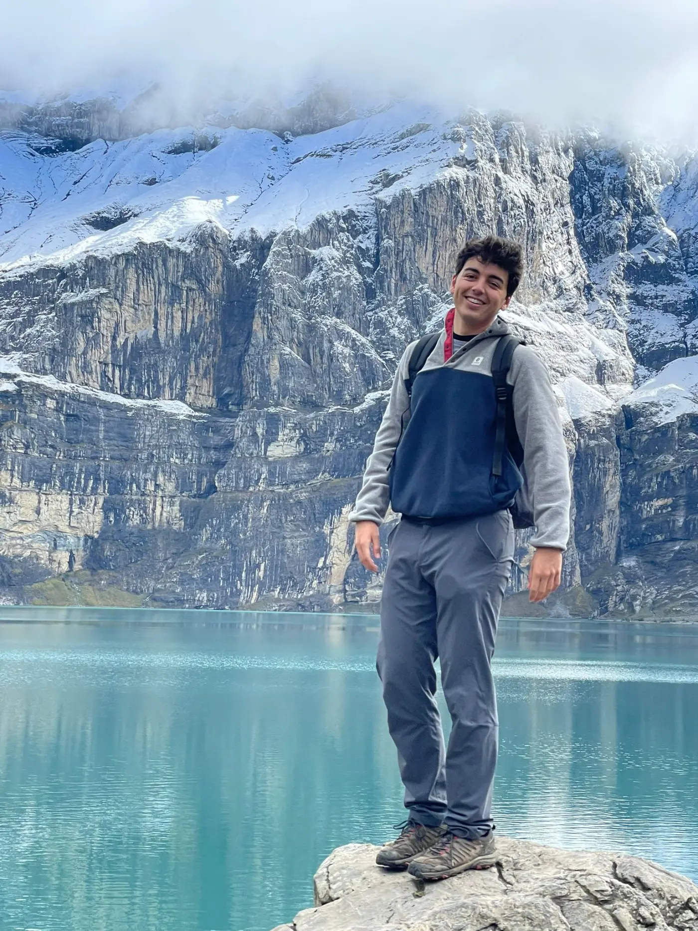 Pablo standing on a rock at Oeschinensee, a glacier lake in the Swiss Alps